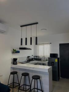 a kitchen with three bar stools and a counter top at Casa Ramona in Loreto +13 photos