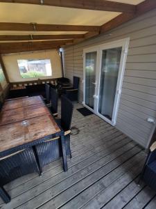 an outdoor deck with a wooden table and chairs at Mobil-home 8 places camping 4 in Pont-Aven