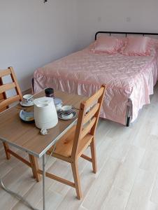 una stanza con un tavolo, sedie e un letto di Chez Lou et Amour a Luché-Pringé