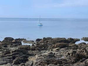 a sailboat is sitting on the rocks in the water at Mobil-home 8 places camping 4 in Pont-Aven +2 photos