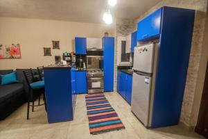a kitchen with blue cabinets and a refrigerator at Chalet in Sahel Mountain view Diplo in Ras Elhekma