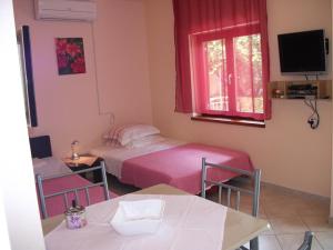 a bedroom with a bed and a table and a window at Apartman Dunja in Gornji Karin