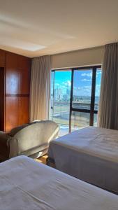 a hotel room with two beds and a large window at KUBITSCHEK - JK APART Hotel in Brasília