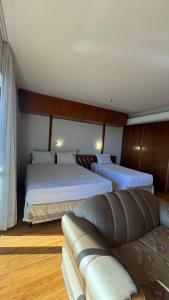 a living room with two beds and a couch at KUBITSCHEK - JK APART Hotel in Brasília