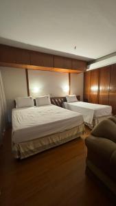 two beds in a hotel room with wooden cabinets at KUBITSCHEK - JK APART Hotel in Brasília