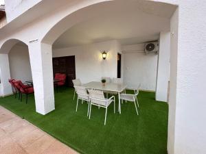 a dining room with a table and chairs on green carpet at El Balcón de Villablancas in La Manga del Mar Menor