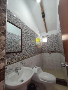 a bathroom with a sink and a toilet and a mirror at Lodge Wayra Wasi in Coporaque +26 photos