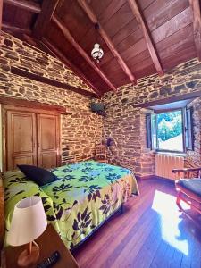 a bedroom with a bed and a brick wall at Casa Freixe Apartamentos Rurales in Santa Eulalia de Oscos