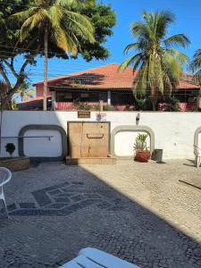 un cortile con un bancone, palme e un edificio di Apartamento para temporada em Cabo Frio a Cabo Frio