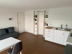 ein Wohnzimmer mit Sofa und eine Küche in der Unterkunft Traumhafter Seeblick mit großer Terrasse in Pogeez