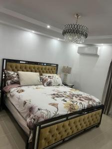 a bedroom with a bed and a chandelier at Residencial Pancho III in Los Mameyes +11 photos