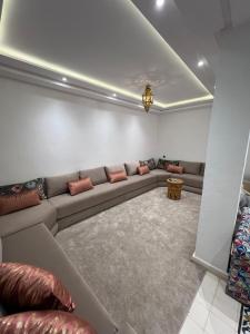 Una sala de estar con un sofá largo en una habitación. en agadir, en Aourir