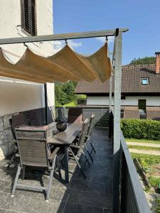 a table and chairs under an umbrella on a patio at Blue Sky Apartment in Bled