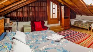 a bedroom with a bed and a red chair at Panoramic City View Terrace House , 5 Bedrooms in Cusco