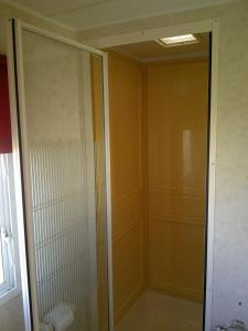 une douche avec une porte vitrée dans une salle de bain dans l'établissement Golden Palm Mirage GP 6 Berth enclosed veranda, à Chapel St. Leonards