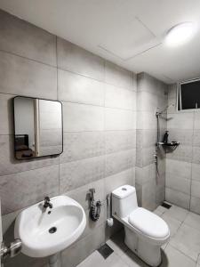 a bathroom with a sink and a toilet and a mirror at Dhia Homestay Sireh Residence Near Aeon Mall in Kota Bharu
