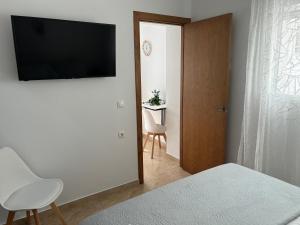 sypialnia z łóżkiem i telewizorem na ścianie w obiekcie APARTAMENTO CALMA EN EL CENTRO w mieście Conil de la Frontera