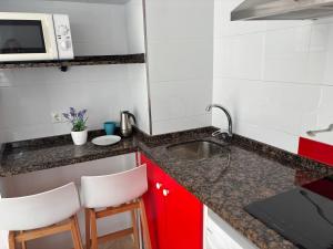 kuchnia ze zlewem i 2 białymi krzesłami w obiekcie APARTAMENTO CALMA EN EL CENTRO w mieście Conil de la Frontera +6 zdjęć