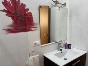 biała łazienka z umywalką i lustrem w obiekcie APARTAMENTO CALMA EN EL CENTRO w mieście Conil de la Frontera