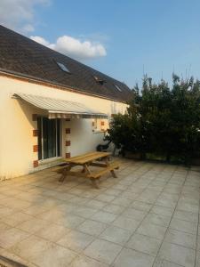 a picnic table on a patio next to a building at Maison de bord de Loire in Sully-sur-Loire