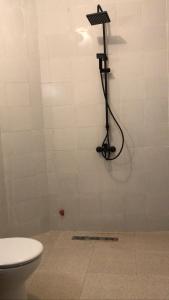a shower in a bathroom with a toilet at Apartment in town, 5 min walk to beach access in Saidia 