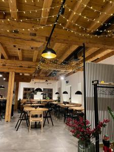 a restaurant with wooden ceilings and tables and chairs at Apartmány Kvilda & Srní in Kvilda