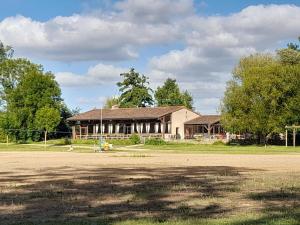 a large building in front of a field at Gîte de baigneux 2 étoiles in Moncontour-de-Poitou