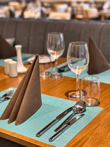 a table with silverware and napkins on a wooden table at Poseidon Beach Resort - Premium All Inclusive & Free Riviera Beach Access in Golden Sands