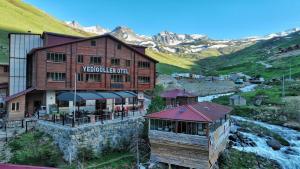 a building with a restaurant in the mountains at Yedigoller Hotel & Restaurant in Uzungöl