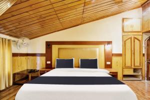 a bedroom with a large white bed and wooden ceilings at Hotel O Hilton Resorts and Spa in Baragrān