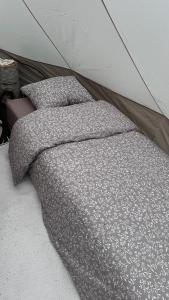a bed with two pillows in a tent at Elämyksellinen majoitus glamping-teltassa in Kokkola