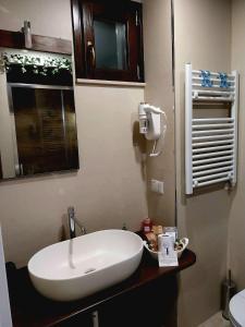 een badkamer met een witte wastafel en een raam bij BELOVED corato in Corato +4 foto's