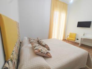 a bedroom with a bed and a yellow chair at AlbaNova in Naples