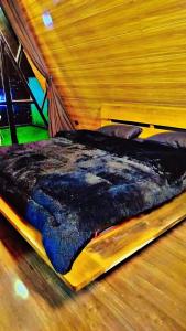 a bed sitting on a wooden floor in a room at Soulter glamps in Dargai