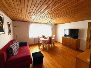 a living room with a red couch and a table at Ferienwohnung Bayerischer Wald in Zwiesel