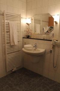 a white bathroom with a sink and a mirror at Ferienwohnungen am Dreiländersee - zertifiziert - Annemarie Mantke in Haltepunkt Driland