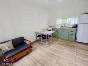 a living room with a couch and a table and a kitchen at Los Eucaliptos Chascomús in Chascomús