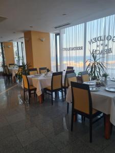 a dining room with tables and chairs in a restaurant at Hotel Golden Beach in Eforie Nord
