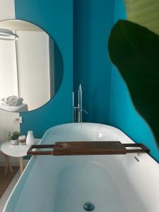 a bathroom with a bath tub with a mirror at LARIMAR Lungomare Vlore in Vlorë +17 photos