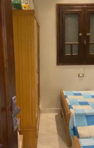 a bedroom with a bed and a wooden cabinet at رأس البر in Ras El Bar