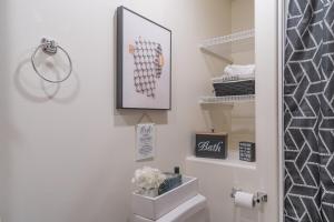 a bathroom with a toilet and a picture on the wall at Modern City Suite 2 in Fairbanks +25 photos