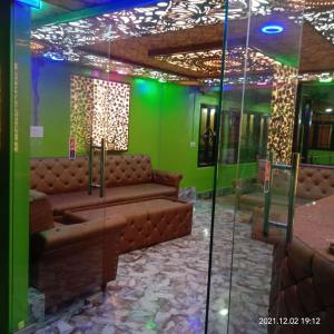 a room with a couch and a green wall at HOTEl momin in Srinagar