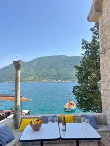 ペラストにあるVilla Sunriseのワイングラスが置かれたテーブル2つと水に浮かぶボート
