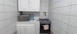 a small kitchen with a stove and a microwave at Coeur urbain in Dakar