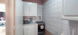 a kitchen with white cabinets and a stove top oven at Coeur urbain in Dakar +10 photos