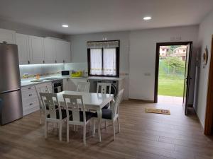 a kitchen with a table and chairs and a refrigerator at Los fresnos de ribadesella 4 personas in Ribadesella