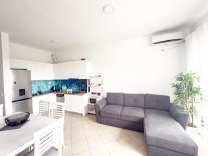 a living room with a couch and a kitchen at LunaSol seaside Apartments in Durrës