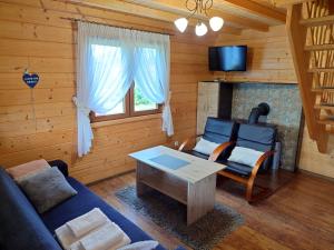 a living room with a couch and a coffee table at Domki u Asi in Wilkasy
