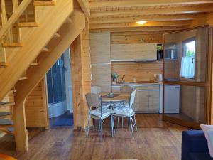 a kitchen with a table and chairs in a cabin at Domki u Asi in Wilkasy