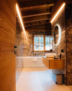 a bathroom with a sink and a bath tub at Sissi green Chalets in Seefeld in Tirol
